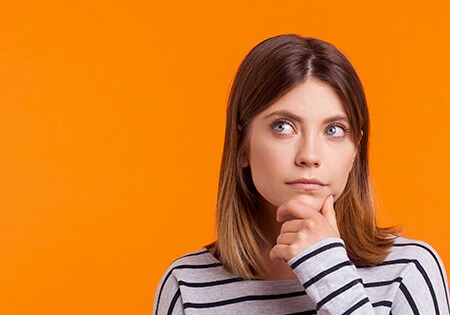 A woman in a striped shirt with her hand on her chin.