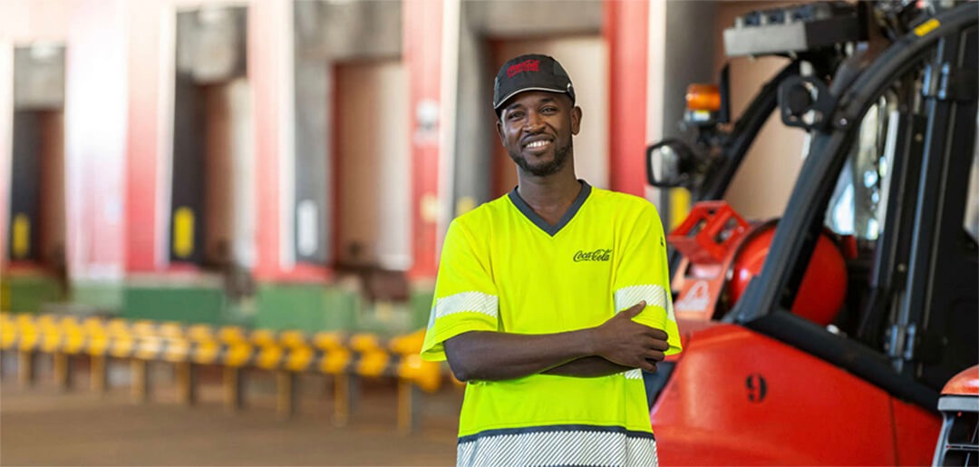 Man standing and smiling next to a lift