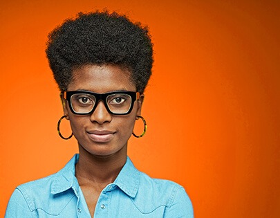 A black woman with glasses on an orange background.